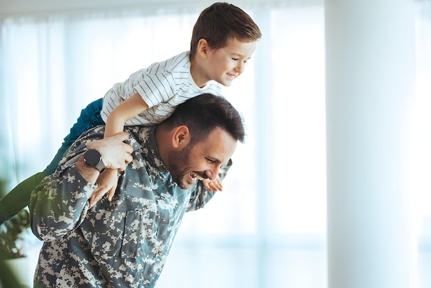 Ojciec wojskowy przytula syna Portret szczęśliwej rodziny amerykańskiej Młody żołnierz właśnie przyjechał do domu