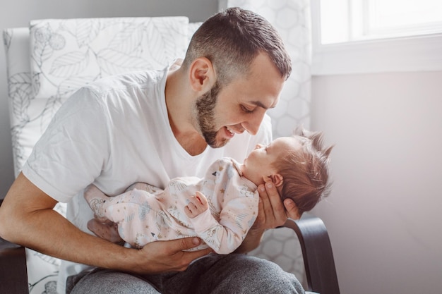 Ojciec z dziewczynką siedzącą na krześle w domu