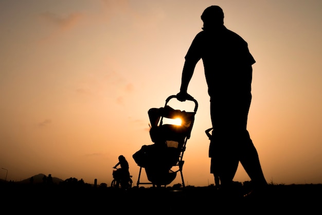 ojciec z małym synem i córką spaceru o zachodzie słońca