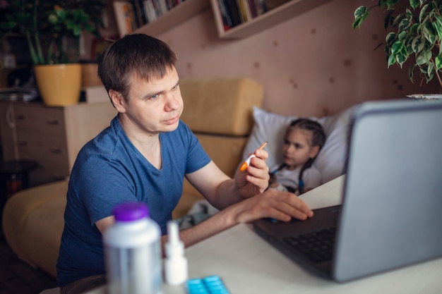 Ojcuje patrzeć ekran laptopu i konsultuje z lekarką online w domu