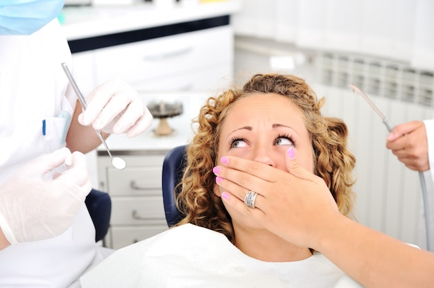 Zdjęcie okaleczająca dziewczyna przy dentystów zębów checkup