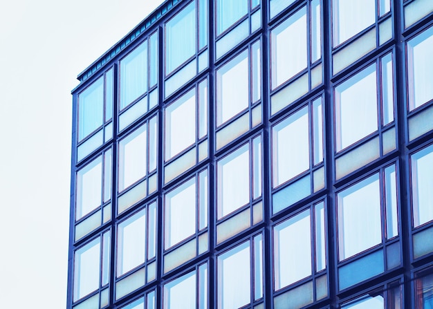 Okna w nowoczesnym futurystycznym szklanym wieżowcu odbijającym błękitne niebo w Helsinkach w Finlandii