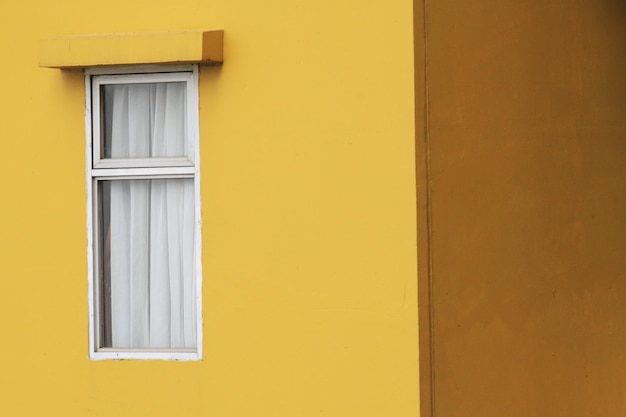 Okno na żółtej ścianie mieszkania