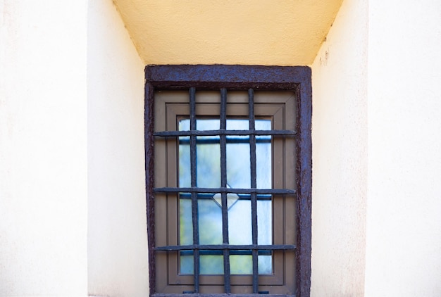 Okno z zardzewiałymi prętami w starym zbliżeniu budynku