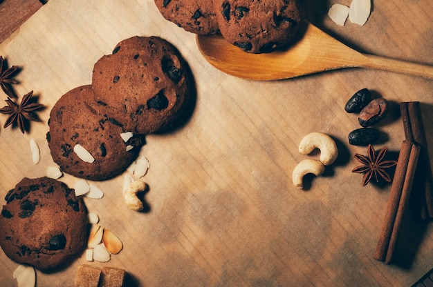 Okrągłe chrupiące czekoladowe ciasteczka z drewnianą łyżką i przyprawami