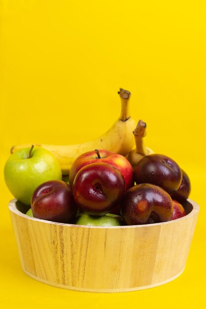 okrągłe pudełko świeżych owoców na żółtym tle