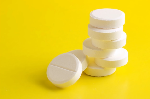 Zdjęcie okrągłe tabletki ułożone na żółtym tle
