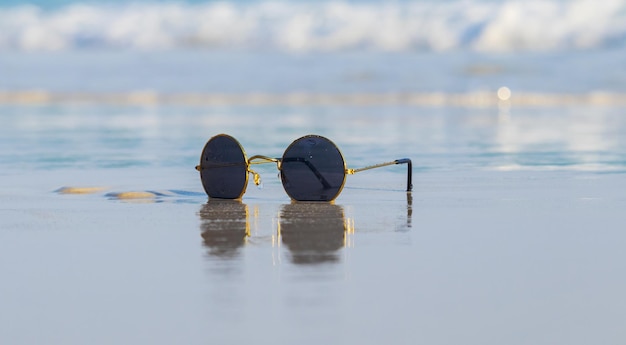 Okulary przeciwsłoneczne na piasku pięknej letniej plaży