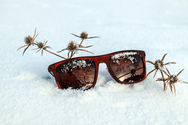 Okulary przeciwsłoneczne na tle białego świeżo opadłego śniegu