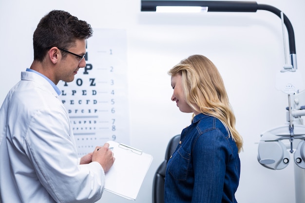Okulista omawia raport z badania wzroku z pacjentką