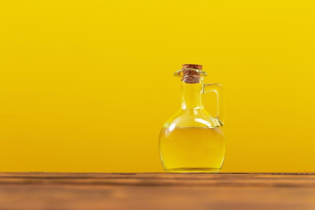 Olej do smażenia w szklanej butelce na żółtym tle