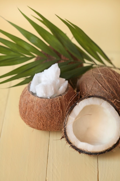 Olej kokosowy. zestaw naturalnego oleju kokosowego, pół kokosa i liści palmowych