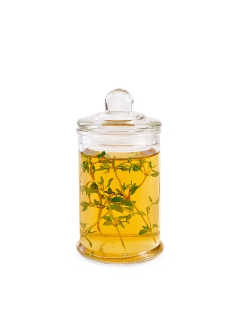 Zdjęcie olej roślinny lub ocet z tymiankiem w szklanym słoju na białym tle