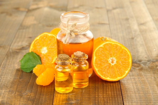 Zdjęcie olejek eteryczny z mandarynki i mandarynki na drewnianym stole
