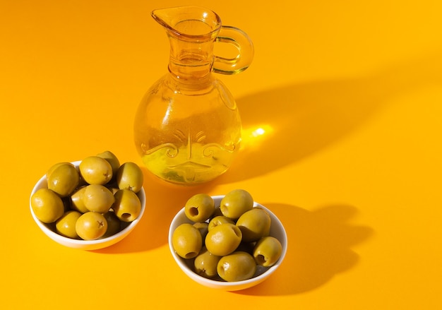 oliwa z oliwek i oliwki na żółtym tle