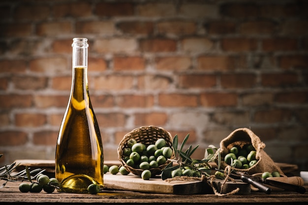 Zdjęcie oliwa z oliwek ze świeżymi oliwkami na rustykalnym drewnie z bliska
