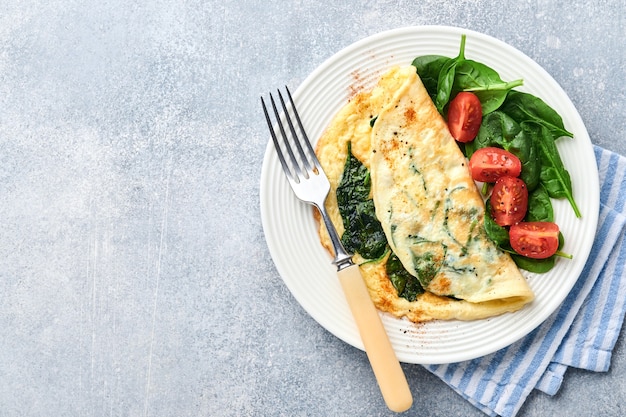 Omlet lub omlet ze szpinakiem, pomidorkami koktajlowymi i przyprawą paprykową