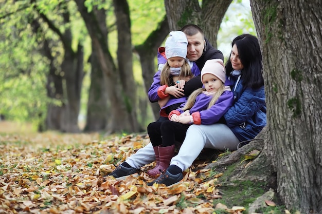 Zdjęcie opadanie liści w parku. dzieci na spacer po jesiennym parku. rodzina. jesień. szczęście.