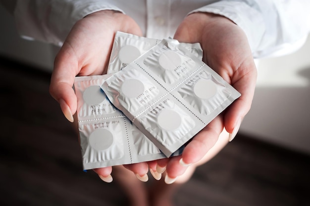 Opakowania tabletek leżące pionowo w kobiecej dłoni Zbliżenie xA