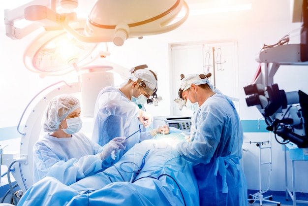 Operacja kręgosłupa. Grupa chirurgów w sali operacyjnej ze sprzętem chirurgicznym.