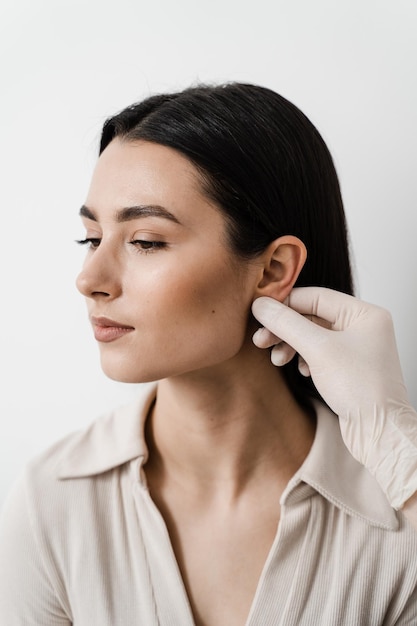 Operacja otoplastyki ucha Otoplastyka chirurgiczna zmiana kształtu małżowiny usznej i ucha Lekarz chirurg bada uszy dziewczynki przed operacją plastyczną otoplastyki