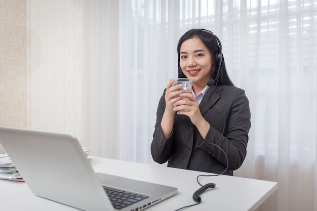 Operator call center. Woda pitna podczas pracy z laptopem.