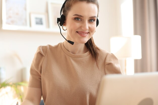 Operator obsługi klienta kobiece z zestawem słuchawkowym i uśmiechnięty.