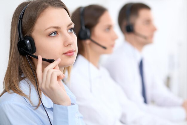 Operatorzy call center. Skoncentruj się na młodej pięknej kobiety biznesu w zestawie słuchawkowym.