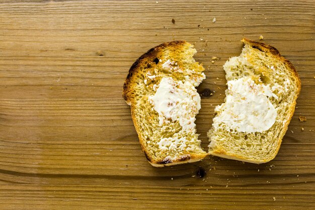 Opiekane kromki świeżo upieczonego chleba na zakwasie z masłem.