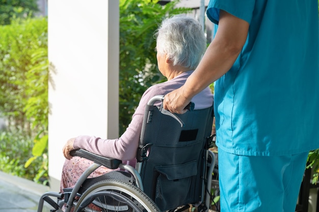 Opiekun pomocy i opieki Azjatycka starsza lub starsza starsza kobieta pacjentka siedząca na wózku inwalidzkim na rampie w szpitalu pielęgniarskim zdrowa silna koncepcja medyczna