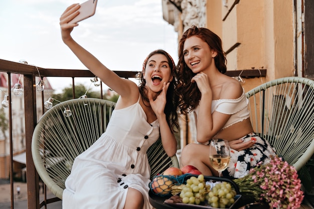 Optymistyczne dziewczyny w dobrym nastroju robią sobie selfie na tarasie