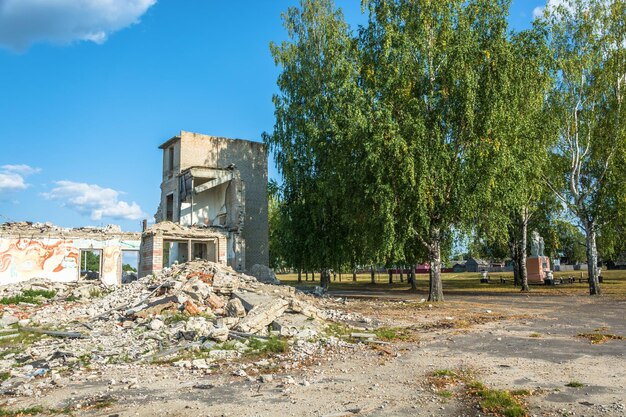 Zdjęcie opuszczony budynek obok drzew na tle nieba