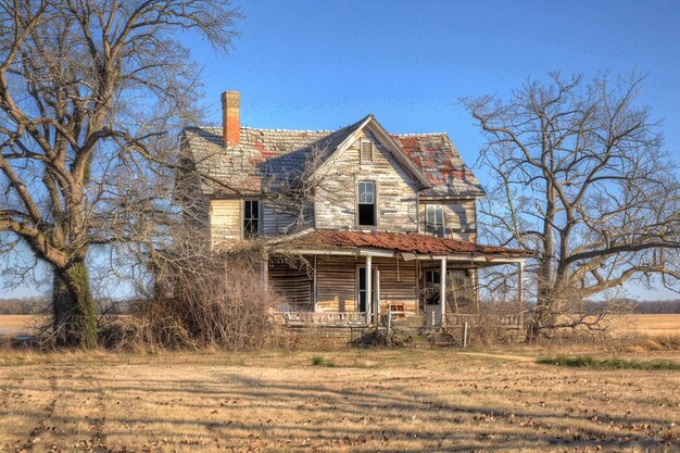 Zdjęcie opuszczony dom na tle z zardzewiałym płotem