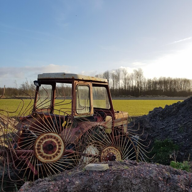 Zdjęcie opuszczony traktor przez farmę przeciwko niebu