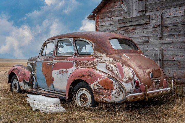 Opuszczony wielokolorowy sedan na preriach w Saskatchewan