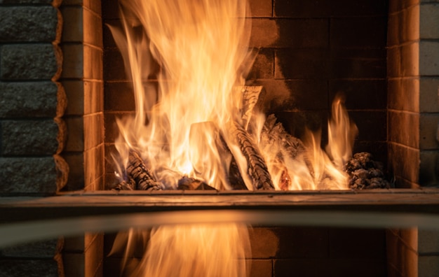 Orange Fire płonie w przytulnym kominku, Boże Narodzenie, ferie zimowe w wiejskim domu.