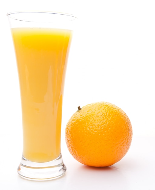 Orange obok szklanki soku pomarańczowego
