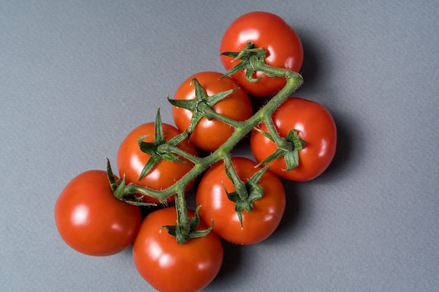 Organiczne pomidory czereśniowe na szarym tle, płaskie świeckich.