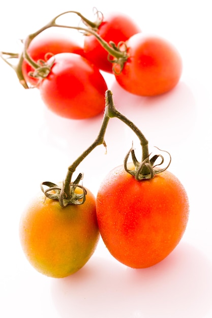 Organiczne pomidory Roma na białym tle.