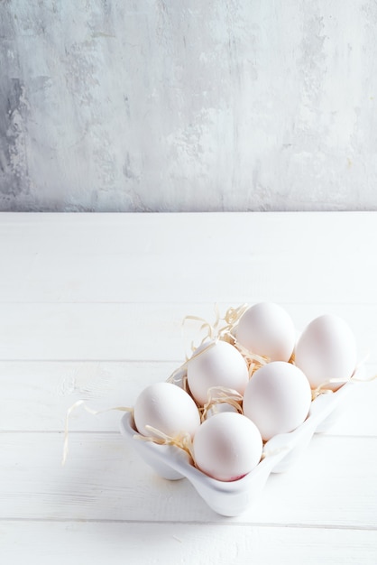 Organicznie biali kurczaków jajka w porcelany dekoracyjnym pudełku na bielu. Naturalne zdrowej żywności i ekologicznej koncepcji.