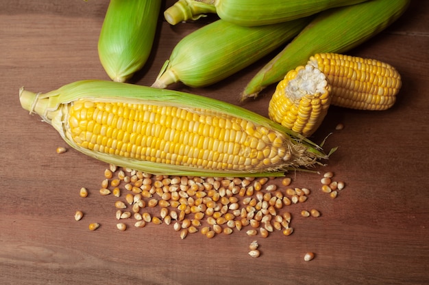 Organicznie świezi corncobs lub kukurydzani ucho na drewnie. Jedzenie dla zdrowie.