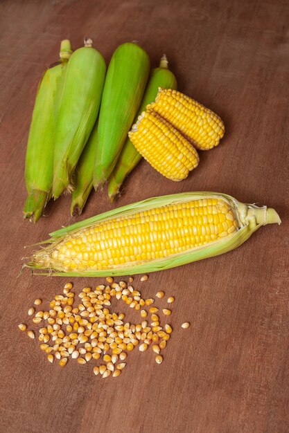 Organicznie świezi corncobs lub kukurydzani ucho na drewnie. Jedzenie dla zdrowie.