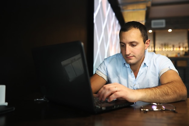 Ormiański przystojny mężczyzna pracujący za laptopem w kawiarni