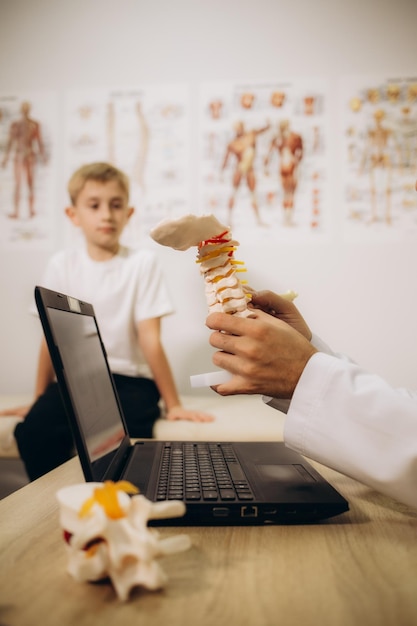 Ortoped badający dzieci z bliska w klinice Leczenie skoliozy