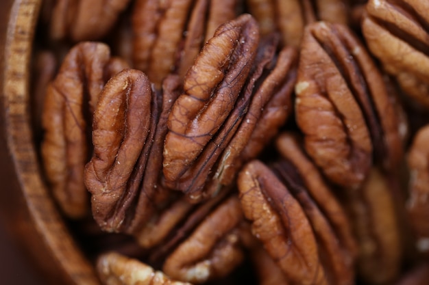 Zdjęcie orzech pekan z bliska w drewnianej misce. zdrowe tłuszcze.
