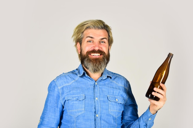 Orzeźwiająca lemoniada Napój gazowany Zimny napój Naucz się robić piwo w domu Robienie domowej roboty Kombuchy Napój gazowany Hipster w barze Mężczyzna trzymaj butelkę za brodę i wąsy Napój alkoholowy