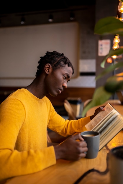 Zdjęcie osoba czytająca książkę w kawiarni