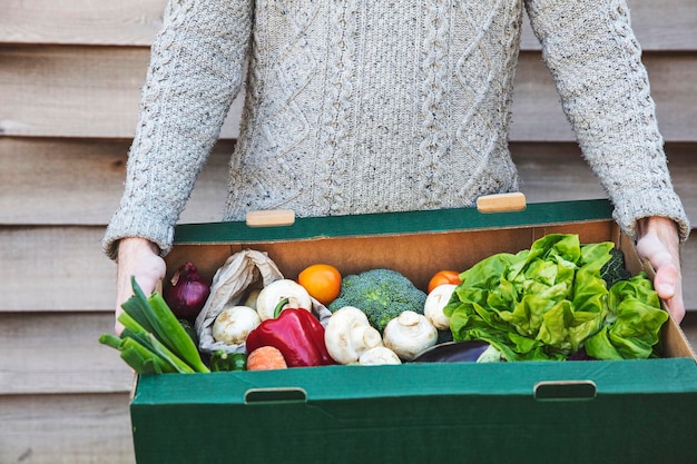 Osoba dostarczająca świeże pudełko warzyw online zakupy żywności ekologicznej