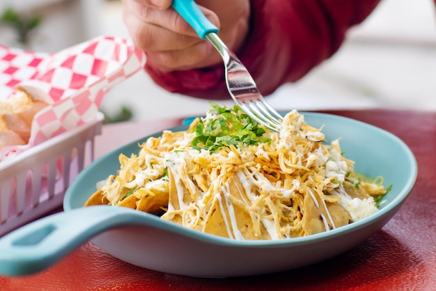 osoba jedząca tradycyjne meksykańskie chilaquiles