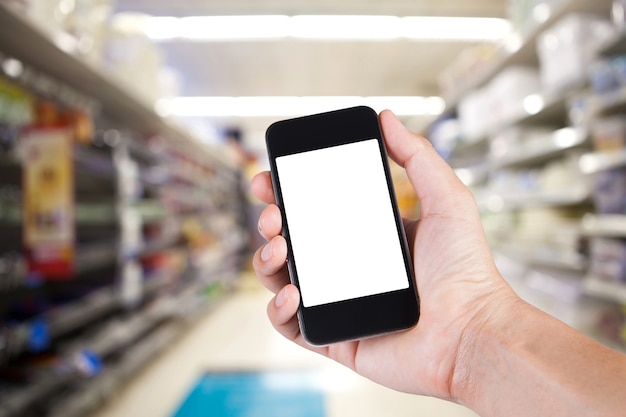 Osoba Korzystająca Z Smartfonu Biały Ekran Posiadacza Na Rękę Z Półkami Na Tle W Supermarkecie.